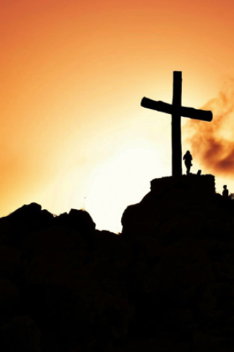 Person standing in front of the cross